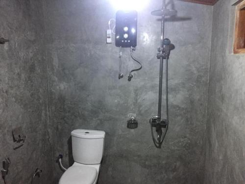 a bathroom with a toilet and a light on the wall at Mount Paradise Ella in Ella