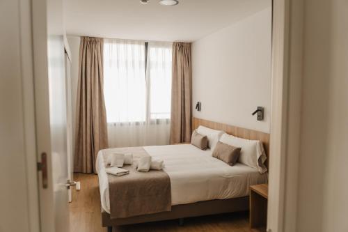 una camera da letto con un grande letto e una finestra di esZentrico Suites Jerez a Jerez de la Frontera