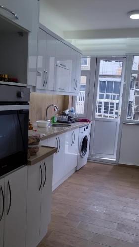 a white kitchen with a sink and a dishwasher at Fawaz apt in Bursa