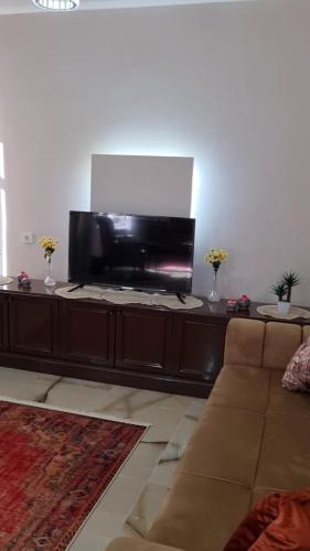 a living room with a couch and a flat screen tv at Fawaz apt in Bursa