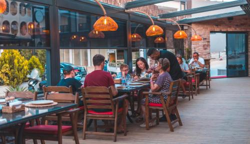 a group of people sitting at tables in a restaurant at Pera Side Hotel in Side