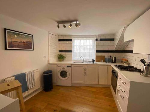 a kitchen with a sink and a washing machine at Sunset views Margate main sands in Kent