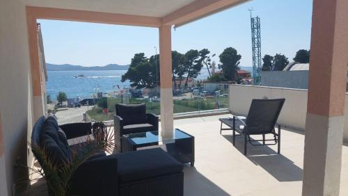 a balcony with chairs and a view of the water at Apartment Nino in Zadar