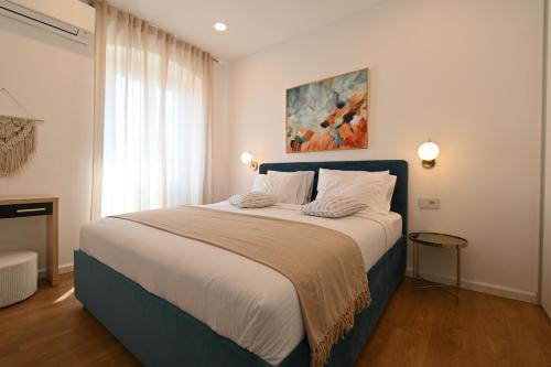 a bedroom with a large bed with a painting on the wall at Apartment Summer Cave in Poreč center in Poreč