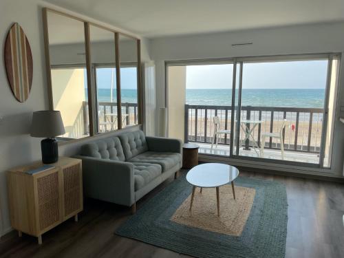 - un salon avec un canapé et une table dans l'établissement Vue mer exceptionnelle à Cabourg, à Cabourg