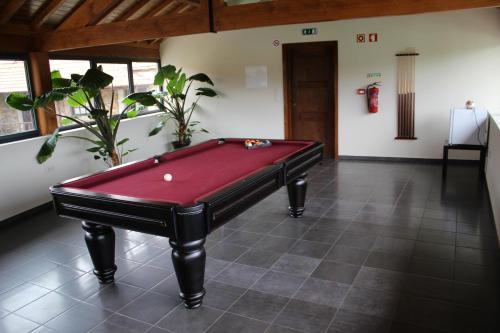 a pool table in a living room with a red at Casa do Villas in Castelo de Paiva