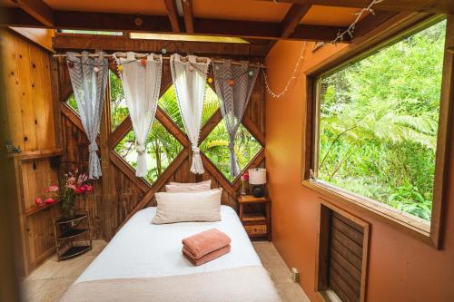 a bedroom with a bed and a large window at Hamakua Sanctuary in Honokaa