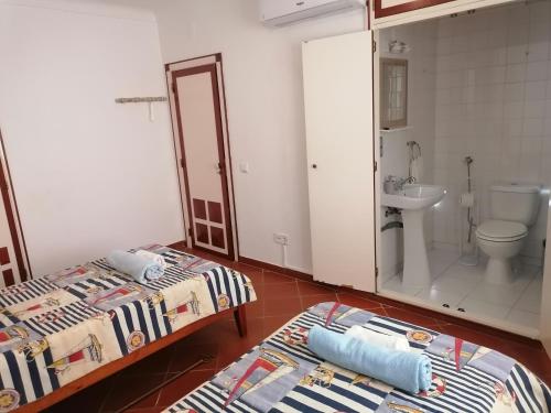 a bathroom with two beds and a toilet and a sink at Villa 46 Hostel in Lagos