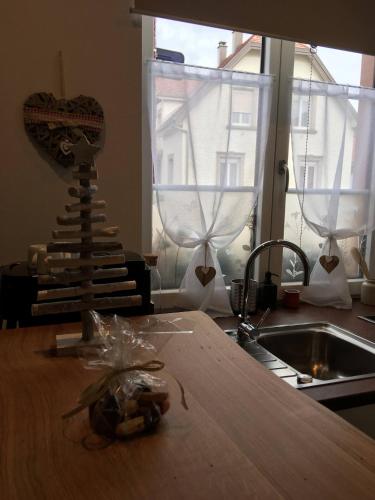 a kitchen with a counter top and a sink and a table at Gîtes De La Bonne Etoile in Geispolsheim
