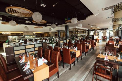 un restaurant avec des tables et des chaises en bois ainsi qu'un bar dans l'établissement Meerbuscher Hof, à Meerbusch