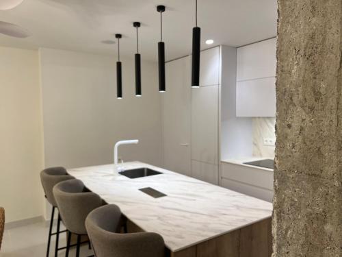 - une cuisine avec un comptoir en marbre et des chaises dans l'établissement Calahonda Turquesa, apartamento en Calahonda Playa, à Calahonda