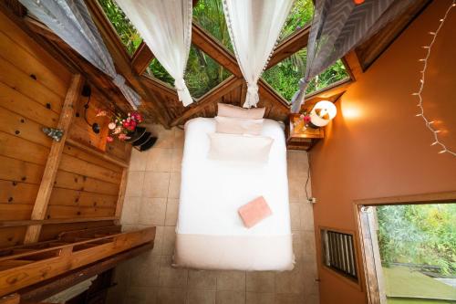 a room in a tree house with a bed in the ceiling at Hamakua Sanctuary in Honokaa