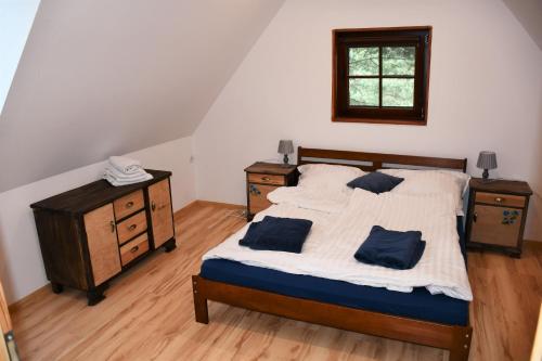 ハジコビにあるCharzykowska Chatkaのベッドルーム1室(青い枕のベッド1台付)