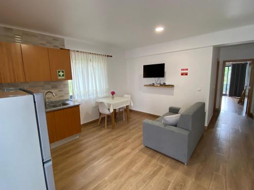 eine Küche und ein Wohnzimmer mit einem Sofa und einem Tisch in der Unterkunft Apartamentos 4 estações in Faja Grande