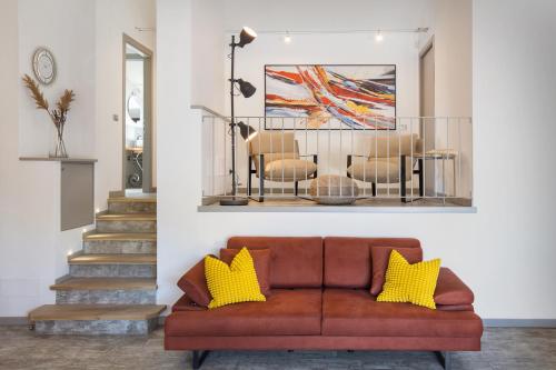 a living room with a brown couch and yellow pillows at Luxury Penthouse/Pool/50m to lake in Bardolino