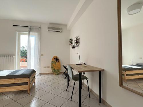 a bedroom with a desk and a bed and a table at Livingapple in Scauri