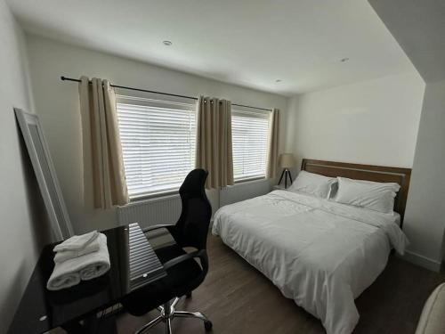 Schlafzimmer mit einem Bett, einem Schreibtisch und einem Stuhl in der Unterkunft Modern 1 Bedroom Studio Flat in Northfleet