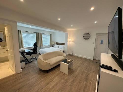 sypialnia z łóżkiem, biurkiem i telewizorem w obiekcie Modern 1 Bedroom Studio Flat w mieście Northfleet