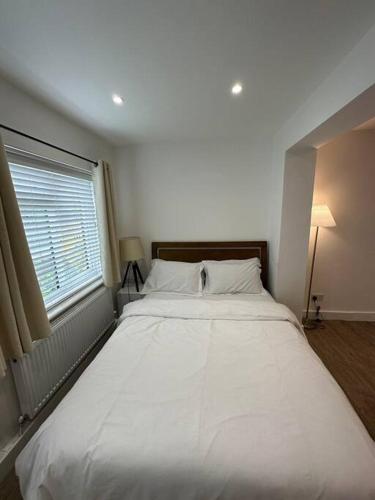 Modern 1 Bedroom Studio Flat في Northfleet: سرير أبيض كبير في غرفة نوم مع نافذة