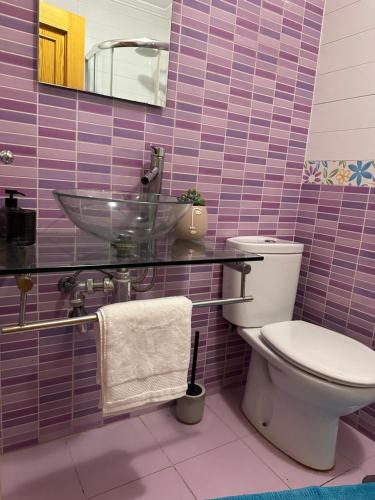 een paars betegelde badkamer met een toilet en een wastafel bij Baiona-Mar, gastronomía y cultura in Baiona