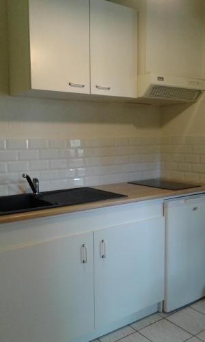 a kitchen with white cabinets and a sink at Gite Sud de France-Carcassonne chez Léa in Aragon
