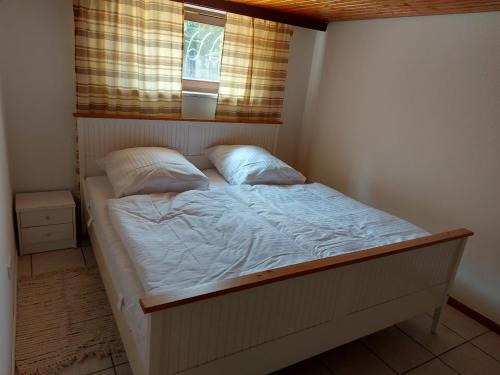 - un petit lit dans une chambre avec fenêtre dans l'établissement Ferienwohnung am Bächle, à Münstertal