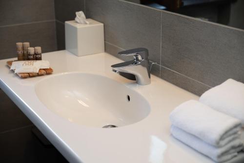 a bathroom sink with a faucet and towels on it at Le Torri - Castiglione Falletto in Castiglione Falletto