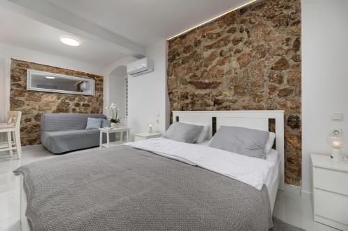 クルクにあるApartment GAVIOTA Krkのベッドと石の壁のある寝室