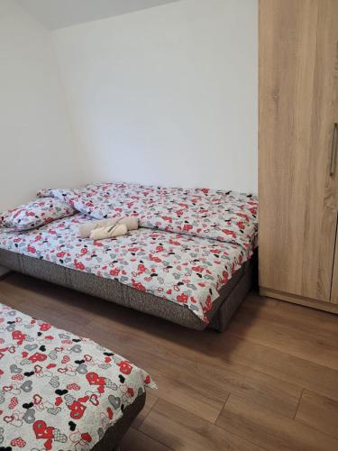a bedroom with a bed with a floral bedspread at Odmorište Vrelo Vape in Sjenica