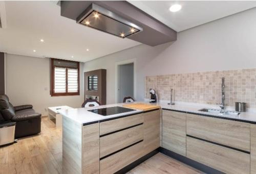 a kitchen with a sink and a living room at a dos pasos de san Mamés in Bilbao