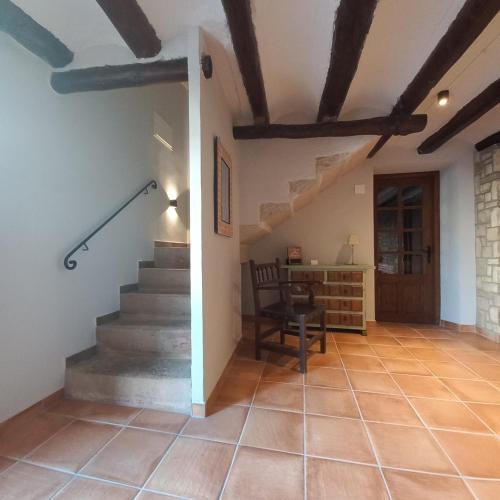 a hallway with stairs and a chair and a desk at La Llacuna in Vila-Sana
