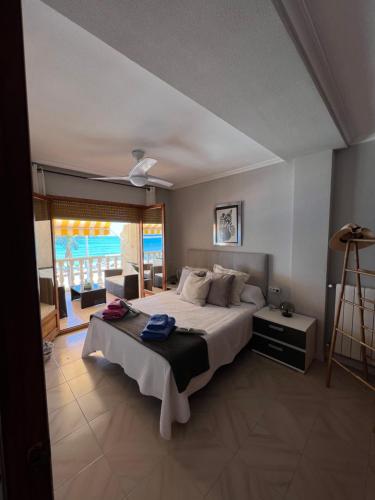 een slaapkamer met een groot bed en een groot raam bij Apartamento frente al mar en El Campello in El Campello