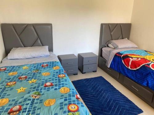 1 Schlafzimmer mit 2 Einzelbetten und blauen Teppichen in der Unterkunft Ola Blanca 2 Sidi Rahal in Zemmour Touirza