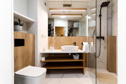a bathroom with a sink and a shower at VacationClub – Ogrody Pieniawskie Apartament 44 in Polanica-Zdrój