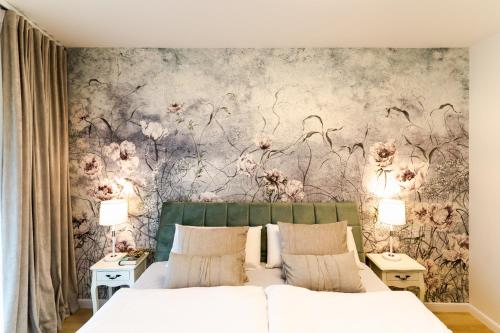 a bedroom with a floral wallpaper on the wall at VacationClub – Ogrody Pieniawskie Apartament 44 in Polanica-Zdrój
