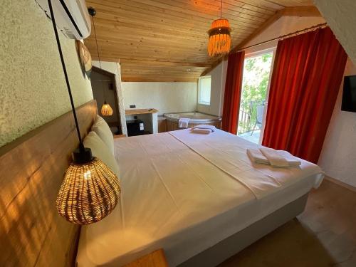 a bedroom with a large bed with a red curtain at Güneş Boutique Hotel - Oludeniz in Oludeniz