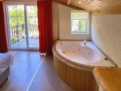 bañera grande en una habitación con ventana en GUNEŞ BOUTIQUE OTEL en Fethiye