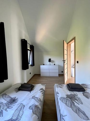 a room with two beds in a room with a door at Szklane Domki Ińsko in Ińsko