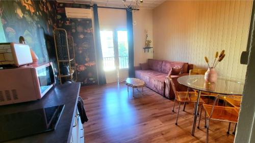 un salon avec un canapé et une table dans l'établissement Petit appartement à 50m à pied de la mer, à Fréjus