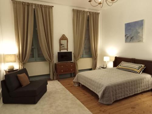 1 dormitorio con 1 cama, 1 silla y TV en 1812 Route de Baziège à Labège en Labège
