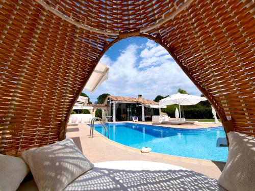- une vue sur la piscine à travers un mur de briques dans l'établissement Chambre d'hôtes & SPA Mas Dels Esquirols, à Saint-André