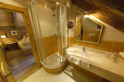 a bathroom with a shower and a sink and a mirror at Landhaus Wastlalm in Sankt Michael im Lungau