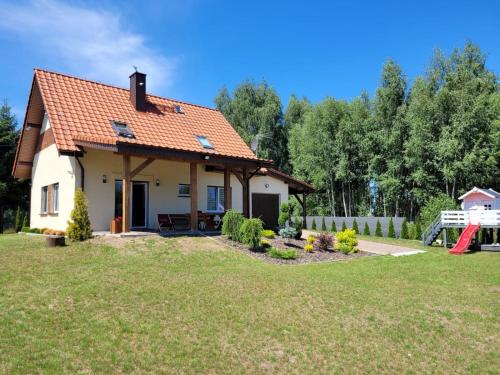 Villa Grunwald في Gierzwałd: بيت أبيض صغير بسقف برتقالي