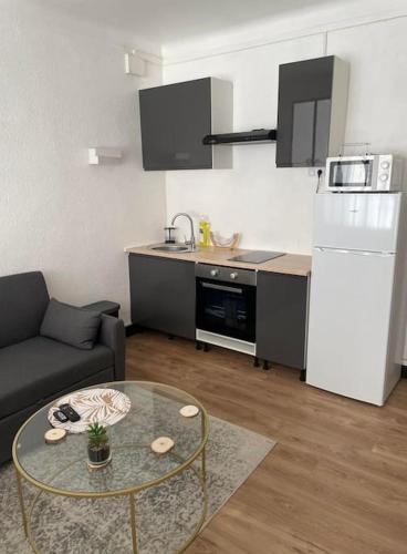 a kitchen with a couch and a table in a living room at Magnifique T1 Bis entièrement refait à neuf in Canet-en-Roussillon