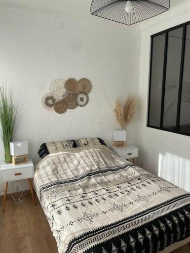 a bedroom with a bed with two night stands and two lamps at Magnifique T1 Bis entièrement refait à neuf in Canet-en-Roussillon