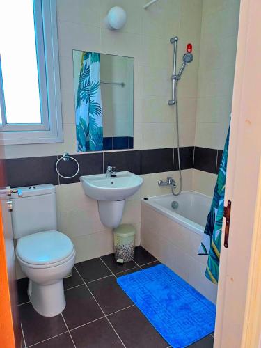 a bathroom with a toilet and a sink and a tub at 3 Bedroom Coral Bay Beach Seaview Villa II Private Pool in Coral Bay