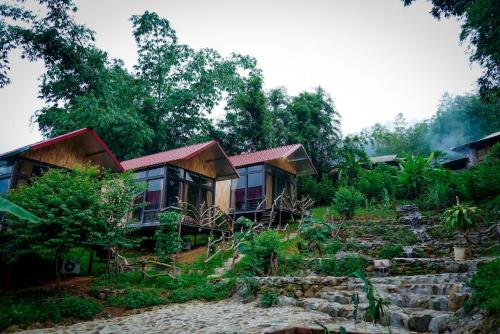 una casa en una colina con árboles en el fondo en Homestay Toan Tra Tram Tau en Cham Ta Lao