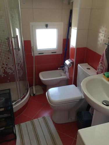 a bathroom with a toilet and a sink and a shower at Apartman Martini in Orikum