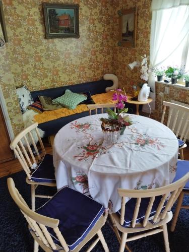 a dining room with a table and chairs with flowers on it at Mysig Stuga På Houtskär in Houtskari