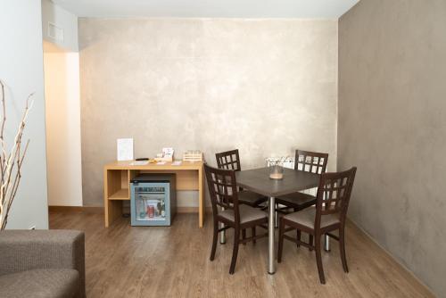 a dining room with a table and chairs and a desk at Le Torri - Castiglione Falletto in Castiglione Falletto